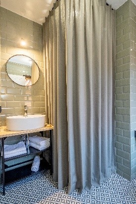 Žalsvos spalvos dušo užuolaida vonios kambario interjere