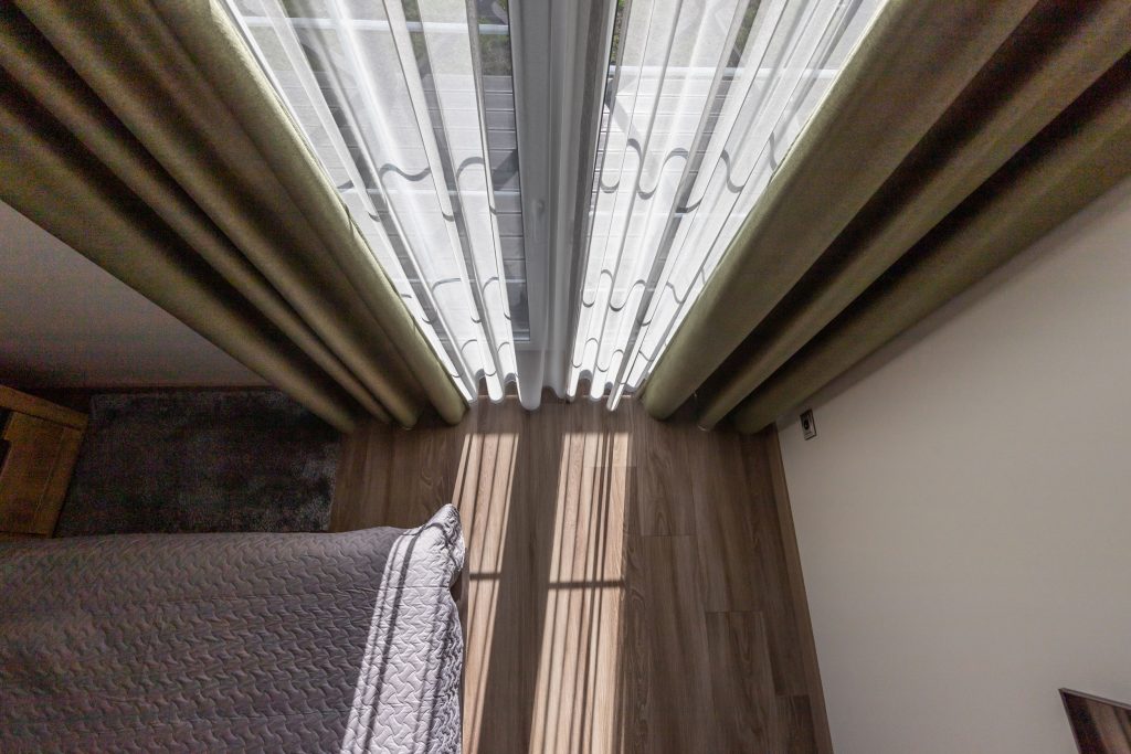 Sodriai žalios spalvos naktinės užuolaidos kliento namų interjere