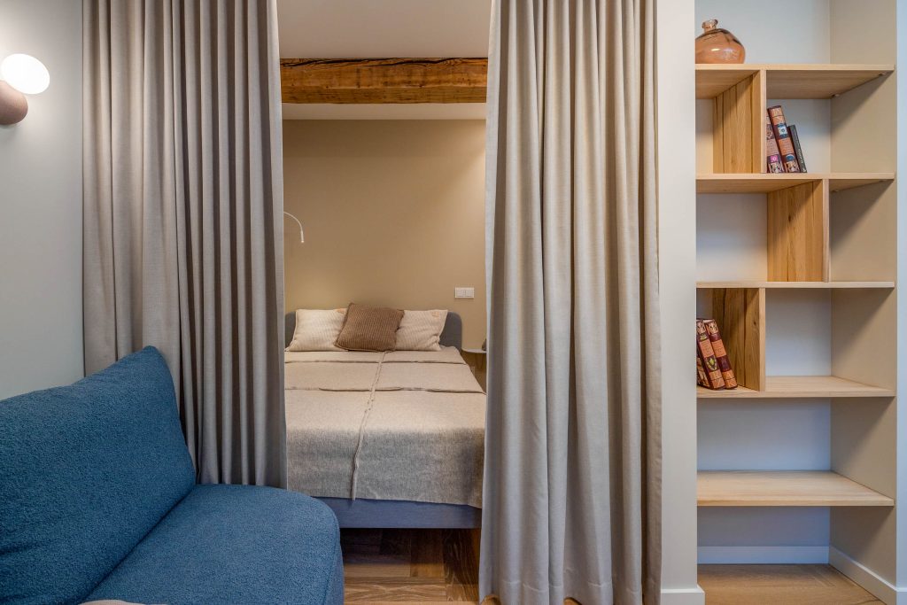 Užuolaida, atskirianti miegamąjį nuo svetainės, sukurianti privatumą interjere