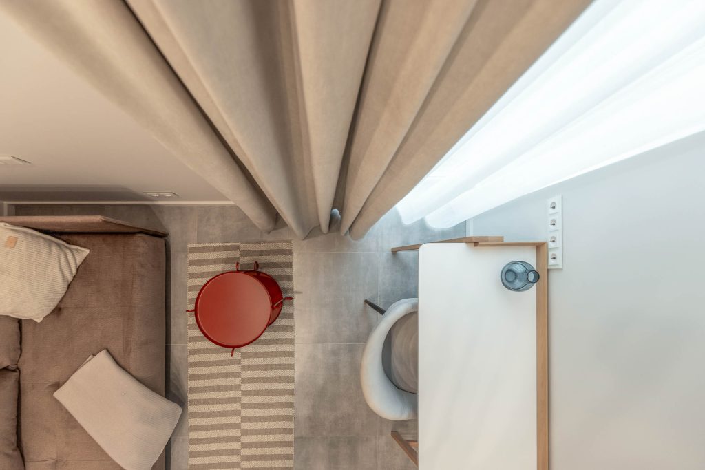 Šviesios spalvos naktinės užuolaidos kliento namų interjere, suteikiančios jaukumo ir šviesos